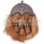 The Fox Fur Dress Sporran is a luxurious accessory that adds a touch of elegance to any Highland outfit. Made from premium red fox fur, this sporran features a striking bronze stag head cantle, symbolizing strength and tradition. Its rich colors and soft texture make it a standout piece for formal occasions. Handcrafted in Scotland by skilled artisans, this sporran showcases exceptional craftsmanship. The natural beauty of the fox fur is complemented by the antique finish of the stag head cantle, creating a unique and eye-catching design. This Fox Fur Dress Sporran is perfect for weddings, Highland games, or any special event where you want to make an impression. Functionality meets style with this sporran. It offers ample storage space for your essentials, ensuring you have everything you need at hand. The interior is lined with soft suede and includes pockets for cards and coins. A durable leather back enhances its longevity, making it a reliable choice for any occasion. The Fox Fur Dress Sporran comes with a matching chain strap for easy attachment to your kilt. Three elegant tassels hang from the front, adding a classic touch that enhances its overall aesthetic. This sporran is designed to pair beautifully with various kilts and formal wear, making it a versatile addition to your wardrobe. Invest in the Fox Fur Dress Sporran to celebrate your connection to Scottish heritage while showcasing your unique style. This exquisite accessory is more than just a sporran; it’s a statement piece that reflects your appreciation for quality and tradition. Make a lasting impression at your next event with this stunning sporran.