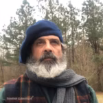 Man wearing a navy blue beret hat with a grey scarf